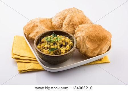 indian semi dry potato spicy recipe also known as aalu bhaji or aalu sabji served with indian puri or poori