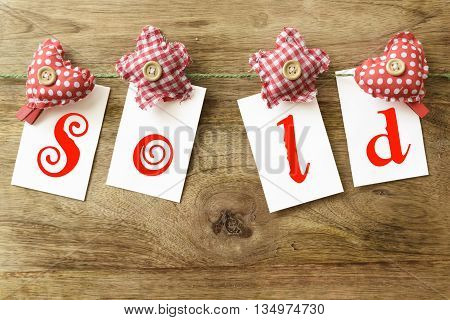 sold written on white note with clothespins