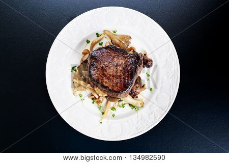 Tasty Beef Mignon steak with mushrooms and herbs on plate