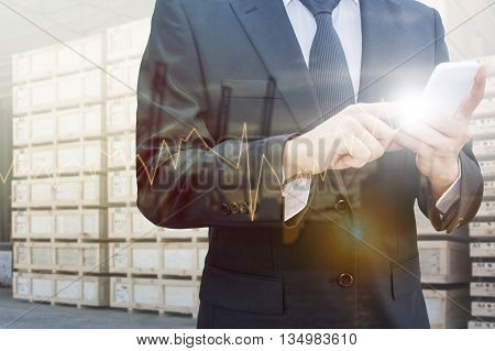 Double exposure of professional businessman using smart phone and city centre of business with blurred transportation port background Technology Transportation & Business trading concept