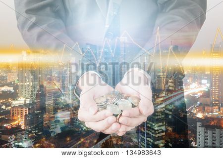 Double exposure of cityscape and businessman collect many coins on hands with trading graph finance and banking concept