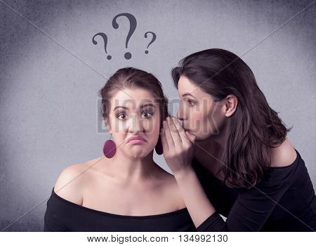 A teenager girl looking confused with drawn question marks above the head, while a girlfriend whispers something in her ear concept.