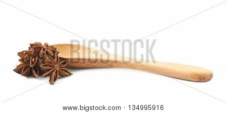 Chinese star anise seed served in a wooden spoon, composition isolated over the white background