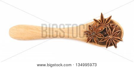 Chinese star anise seed served in a wooden spoon, composition isolated over the white background