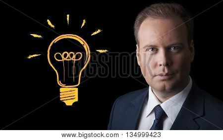 portrait of a businessman with an idea on a black background