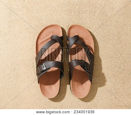 Vintage Brown Sandals On Sand Of Beach From Top View