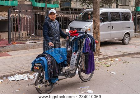 Beijing, China - April 26, 2010: Unregistered Ambulant Woman Sells Fabrics And Clothes Off Her Motor