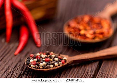 Wooden Spoons With Dried Ginger, Peppercorn And Red Chili Pepper On Wooden Background. Selective Foc