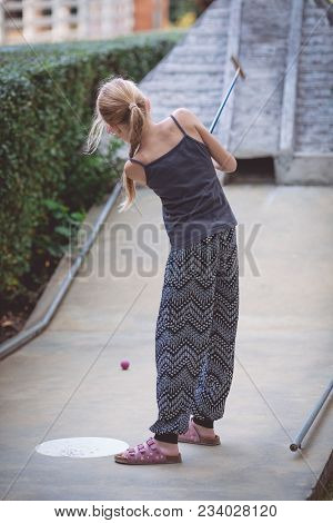 Happy Little Girl  Playing Mini Golf.