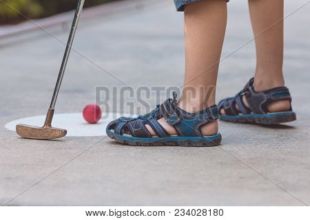 Happy Little Boy  Playing Mini Golf.