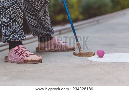 Happy Little Girl  Playing Mini Golf.