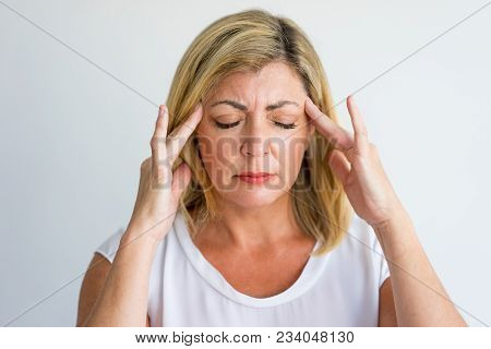 Annoyed Woman Feeling Pain Touching Temples While Trying To Concentrate. Puzzled Businesswoman Havin