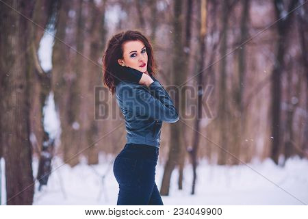 Girl Brunette Against The Background Of The Winter Forest