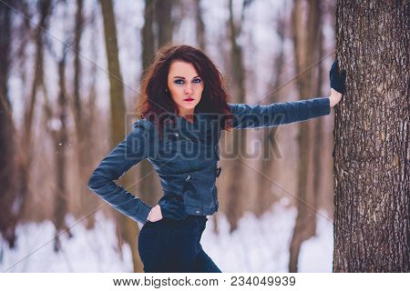Girl Brunette Against The Background Of The Winter Forest