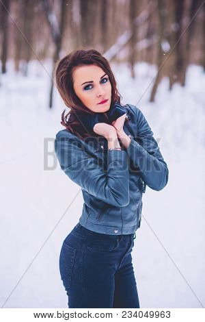 Girl Brunette Against The Background Of The Winter Forest