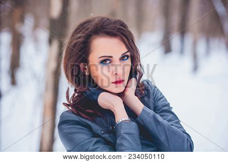 Girl Brunette Against The Background Of The Winter Forest