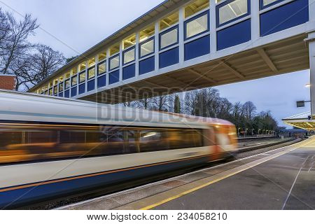 Train Passing Through A Station On A Mainline Out Of London