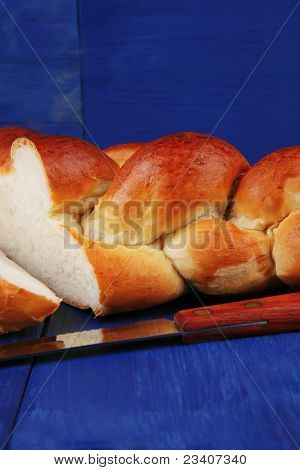 pečený výrobek: broušená zlatý Chala na modré dřevěný stůl