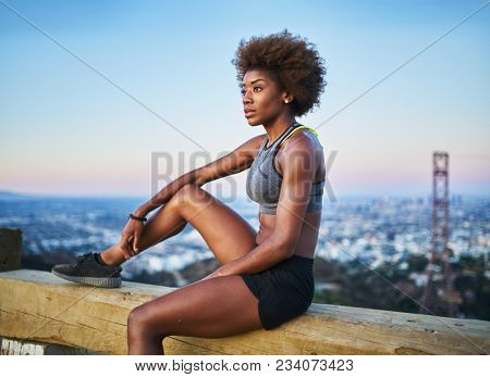 fit african woman woman resting on bench at runyon canyon shortly after sunset               