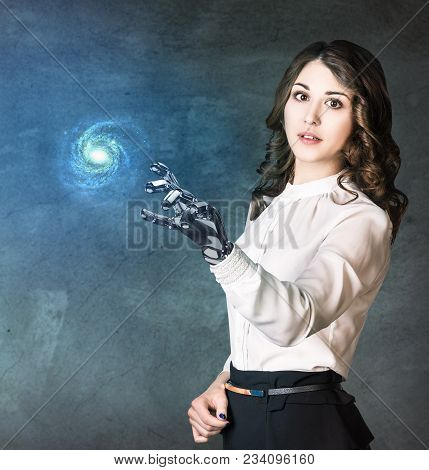Young Business Woman With Robot Hand Point On Galaxy. Elements Of This Image Furnished By Nasa.