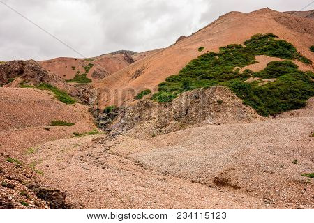 Icelandic Landscape With Red Hills In Lonsoraefi In Cloudy Weather