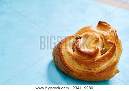 Homemade Rose Bun With Raisins And Cream On Blue Background, Close-up, Shallow Depth Of Field. Aroma