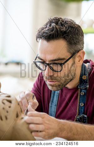 Ceramist Dressed in an Apron Sculpting Statue from Raw Clay in the Bright Ceramic Workshop.