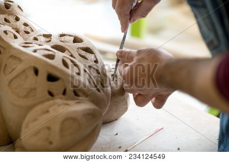 Ceramist Dressed in an Apron Sculpting Statue from Raw Clay in the Bright Ceramic Workshop.