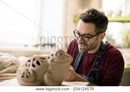 Ceramist Dressed in an Apron Sculpting Statue from Raw Clay in the Bright Ceramic Workshop.