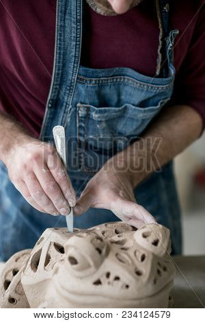 Ceramist Dressed in an Apron Sculpting Statue from Raw Clay in the Bright Ceramic Workshop.