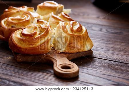 Homemade Rose Buns With Raisins On Wooden Cutting Board Over Rustic Vintage Background, Close-up, Sh