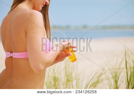 Skin Protection In Summer. Woman On Beach Using Sun Oil. Young Beauty Girl Taking Sunbath On Sunny D