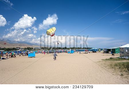 People Enjoy Sandy Beach Near Cholpon-ata Beach , Issyk-kul Lake, Kyrgyzstan 30.07.2017