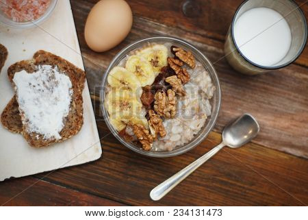 Breakfast With Granola Bowl, Muesli With Oats, Nuts And Dried Fruit, Milk, On Wooden Table. Bannana,