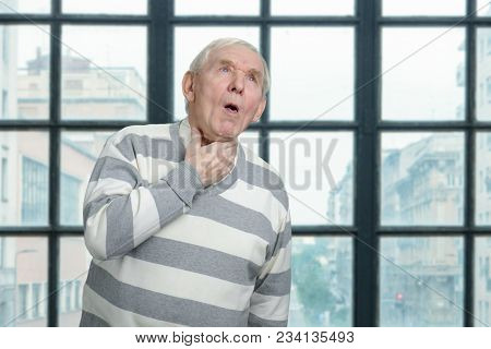 Old Man Is Coughing. Sick Senior Man In Windows Background.