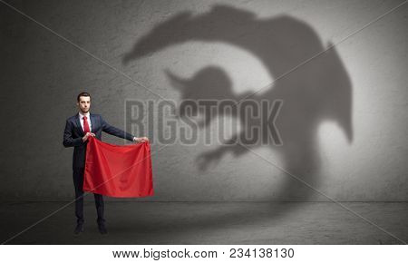 Businessman standing with red cloth in his hand and imp shadow on the background