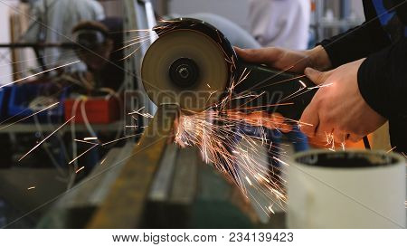 Worker Sawing Metal Bar Of Angular Grinding Machine.