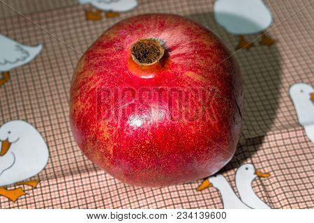 Wholesome Ripe Pomegranate Fruit In Red Scabrous Peel On A Cute Tablecloth.