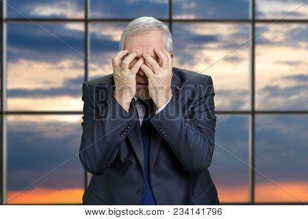Portrait Of An Old Stressed Business Man. Senior Man In Suit Extremely Sad And Dissapointed, Blue Ev