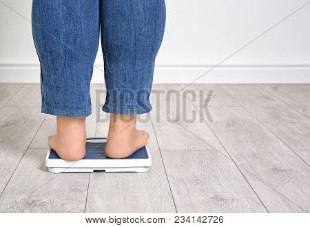 Overweight Woman Legs Using Scales Barefoot Indoors