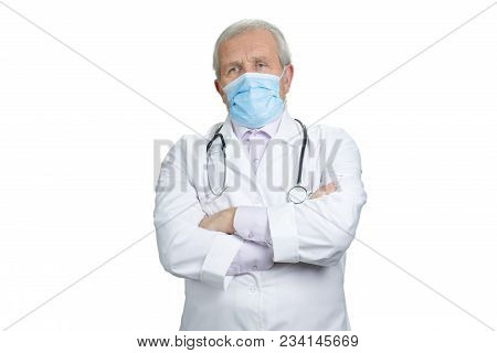 Old Senior Doctor In Medical Protective Mask. Portrait Of Physician With Folded Arms. White Isolated