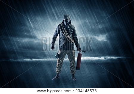 Terrorist in a stormy space with gas mask on his hand and weapons on his arm
