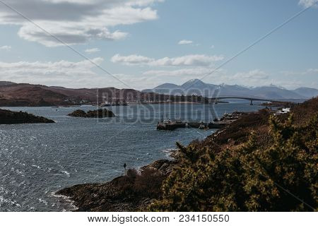 View Of Skye Bridge And A Small Coastal Village On Isle Of Skye, Scotland, On A Sunny Day. View From