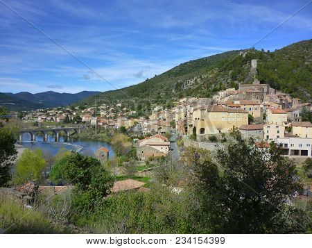 The Village Of Roquebrun Sitting On The River Orb In The Haut Languedoc, France