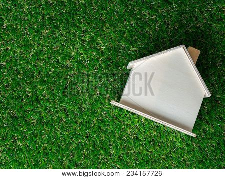 Wooden House Model Placed On A Green Lawn. Eco House Concept