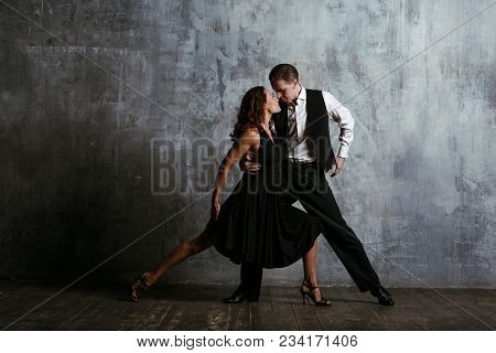 Young Pretty Woman In Black Dress And Man Dance Tango