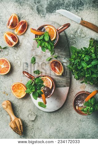 Blood Orange Moscow Mule Alcohol Cocktails With Fresh Mint Leaves And Ice In Copper Mugs On Board In