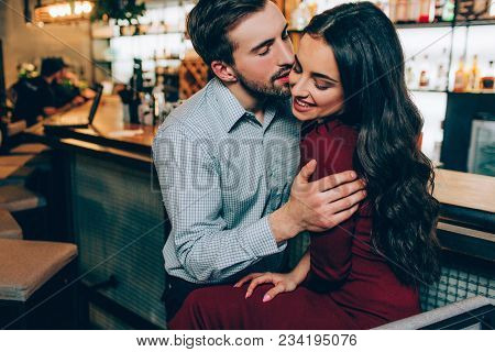 Lovely Picture Of Handsome Man And Beautiful Woman Sitting Very Close Together. He Is Holding Her On