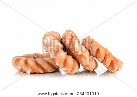 Four Glazed Cruller Donuts In Pile Isolated White Background