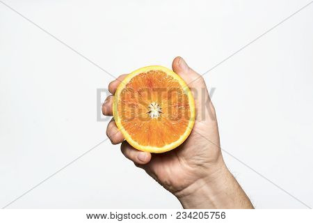 A Cut Orange Fruit In The Hand